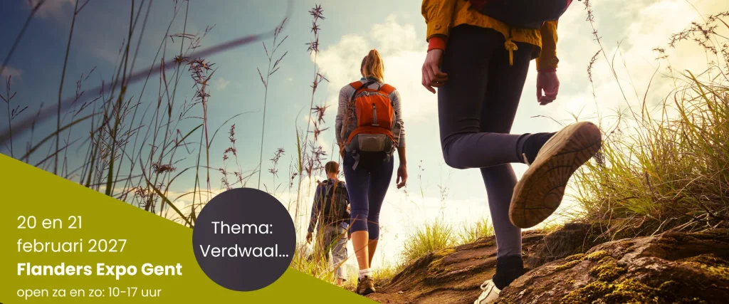 Drie wandelaars lopen door het gras tijdens een wandelvakantie